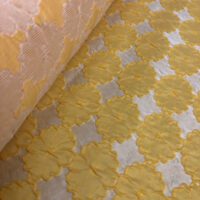 A close up of the fabric for a yellow and white dress