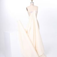 A white dress is on display in front of a mannequin.