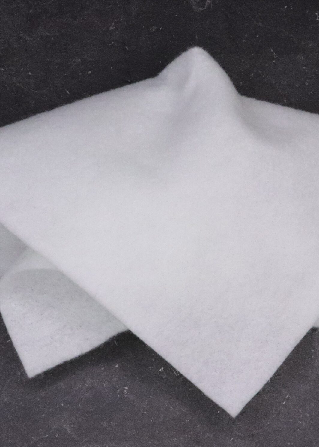 A white napkin folded on top of another cloth.
