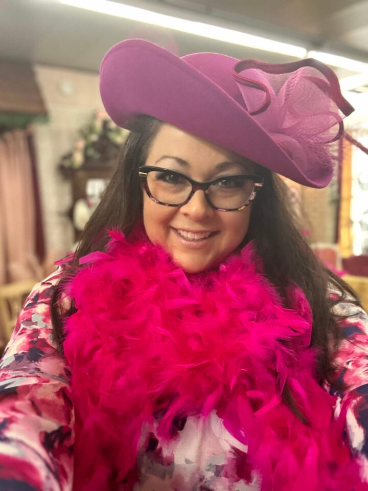 A woman wearing glasses and a pink hat.